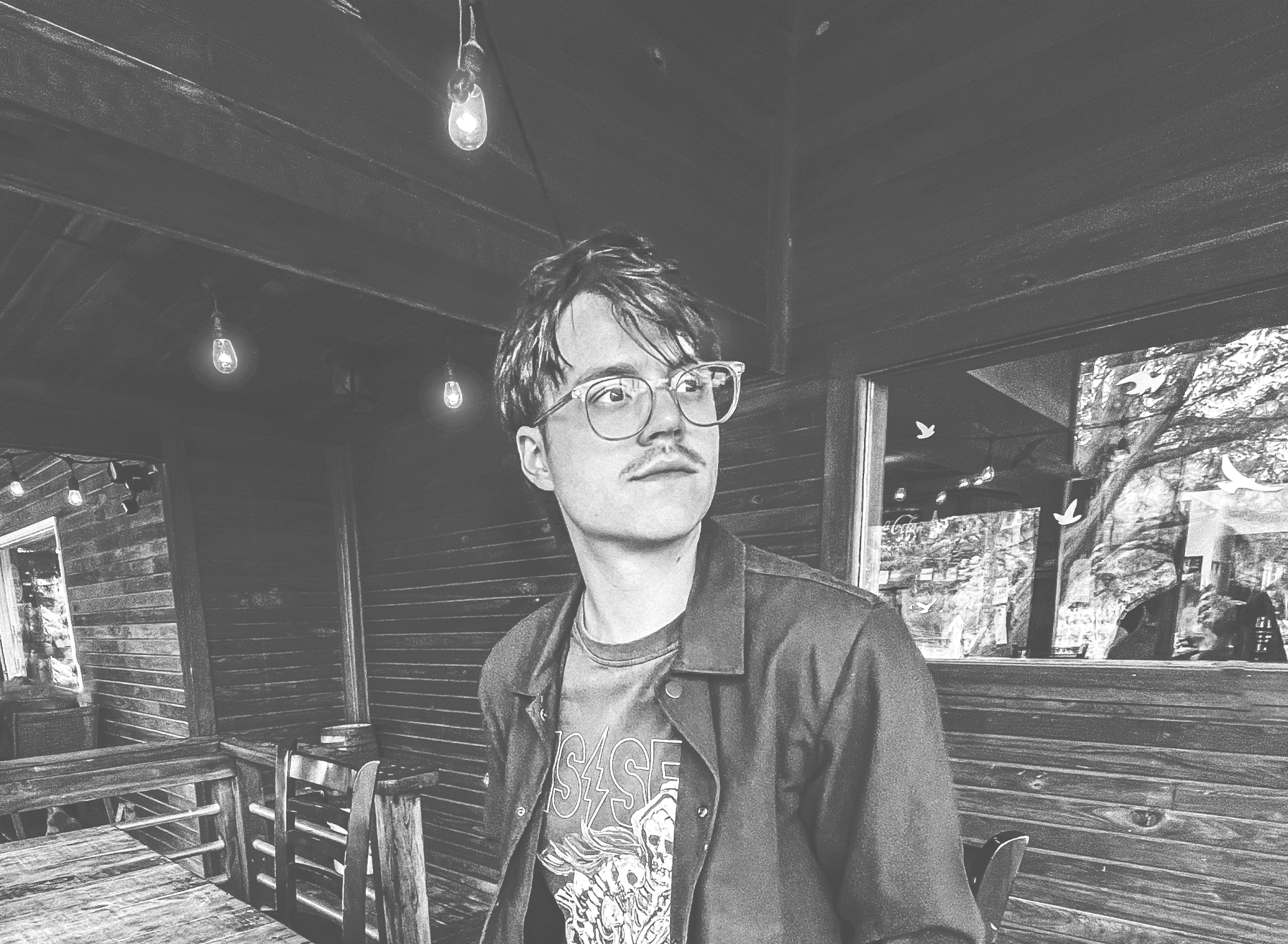 a black and white photo of David Markham sitting on a porch